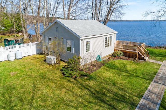 view of side of property featuring a deck with water view and roof with shingles