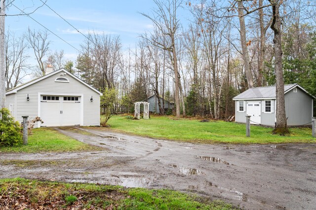 detached garage featuring dirt driveway