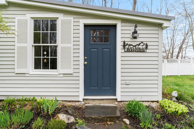 view of exterior entry featuring fence