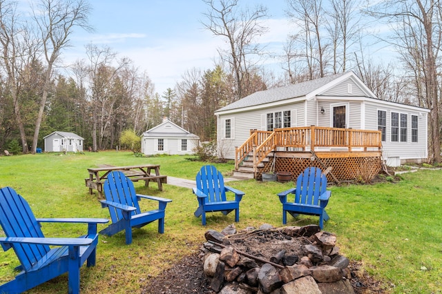 view of grassy yard with an outdoor fire pit and a deck