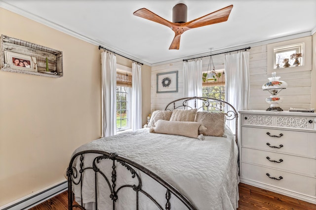 bedroom with a baseboard heating unit, ornamental molding, dark wood-style flooring, baseboards, and ceiling fan