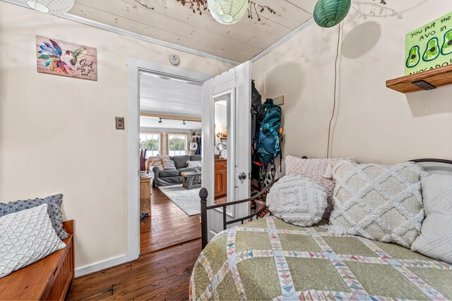 bedroom featuring hardwood / wood-style floors, crown molding, and baseboards