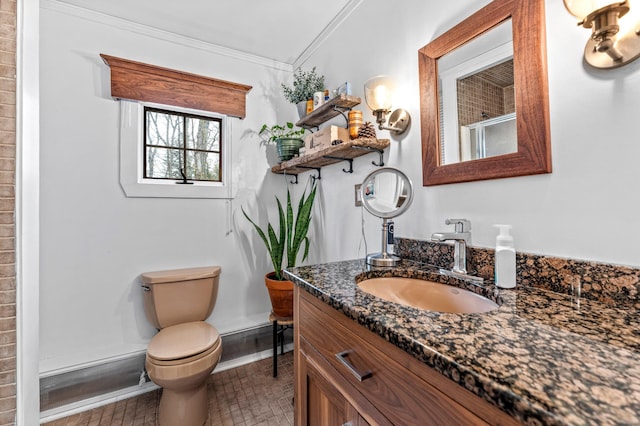 bathroom with ornamental molding, baseboards, toilet, vanity, and a shower