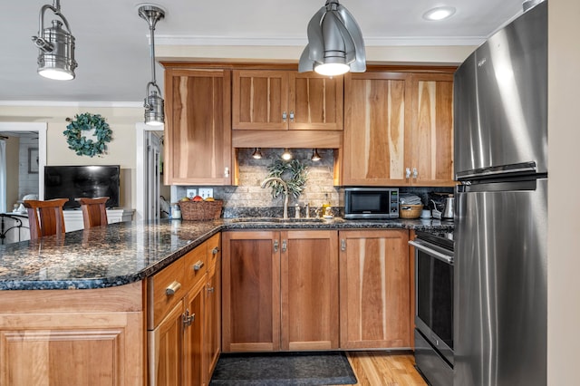 kitchen featuring stainless steel appliances, a sink, tasteful backsplash, brown cabinetry, and crown molding