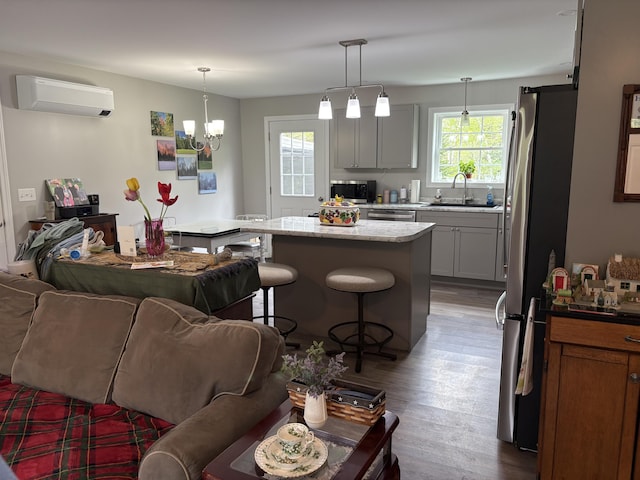 38 Deer Ridge Ln, Windsor, ME 04363 - kitchen featuring appliances with stainless steel finishes, a wall mounted air conditioner, open floor plan, a sink, and a breakfast bar area
