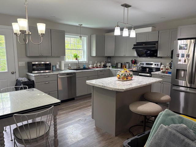 38 Deer Ridge Ln, Windsor, ME 04363 - kitchen with stainless steel appliances, gray cabinets, a sink, a breakfast bar area, and a kitchen island