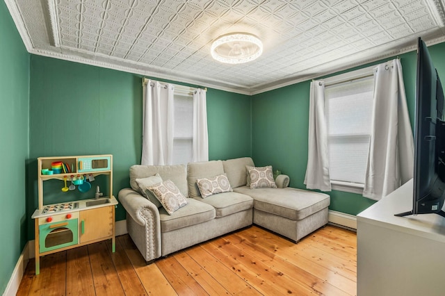 148 Water St, Randolph, ME 04346 - living room with an ornate ceiling, baseboard heating, hardwood / wood-style floors, crown molding, and baseboards