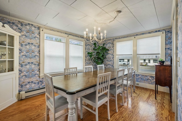 148 Water St, Randolph, ME 04346 - dining room featuring wallpapered walls, light wood finished floors, a chandelier, a baseboard radiator, and crown molding
