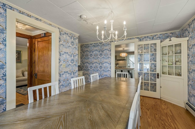 148 Water St, Randolph, ME 04346 - unfurnished dining area with wallpapered walls, a chandelier, a baseboard heating unit, wood finished floors, and ornamental molding