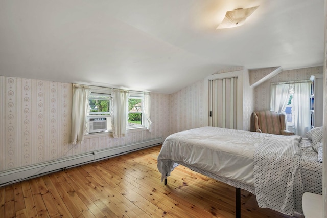 148 Water St, Randolph, ME 04346 - bedroom with wallpapered walls, baseboard heating, hardwood / wood-style flooring, cooling unit, and lofted ceiling