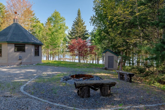 139 Havey Point Rd, Hancock, ME 04640 - view of yard with an outdoor fire pit, a storage unit, and a water view