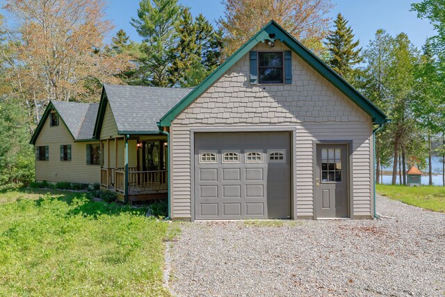 139 Havey Point Rd, Hancock, ME 04640 - view of front facade featuring a shingled roof, an attached garage, driveway, covered porch, and a front yard