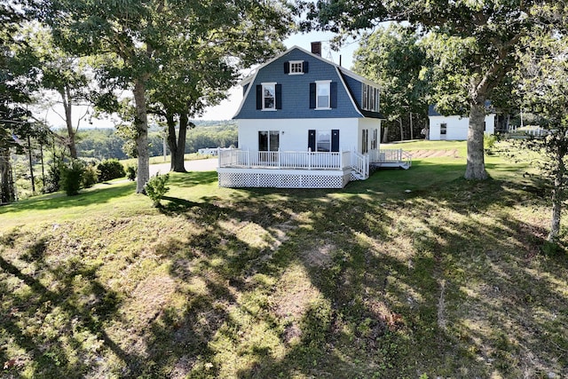 5 Polka Valley Rd, Sedgwick, ME 04676 - rear view of house featuring a deck, a yard, a chimney, and a gambrel roof
