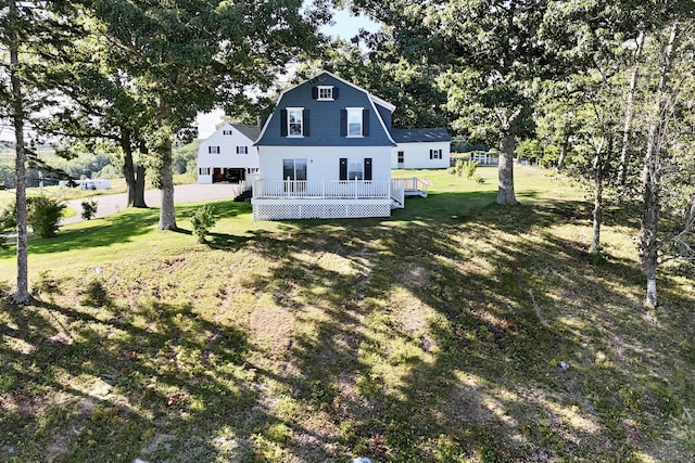 5 Polka Valley Rd, Sedgwick, ME 04676 - back of house with a gambrel roof, a wooden deck, and a lawn
