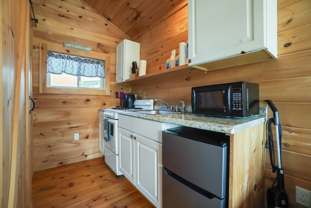 1270 Lakeview Dr Unit 11, China, ME 04358 - kitchen with freestanding refrigerator, black microwave, a sink, white cabinetry, and wood walls