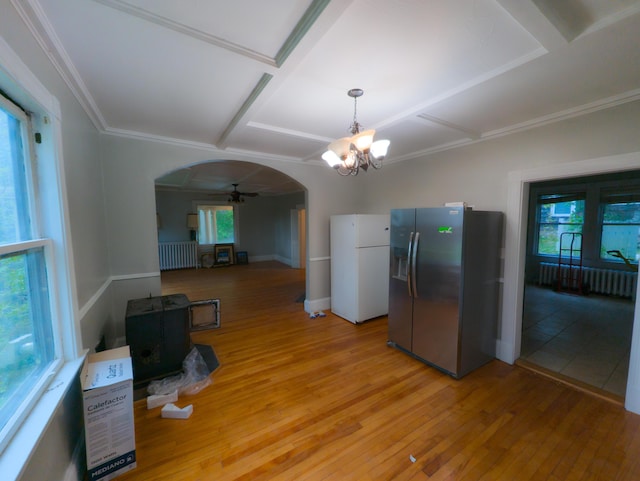 kitchen with stainless steel fridge with ice dispenser, arched walkways, freestanding refrigerator, coffered ceiling, and radiator heating unit