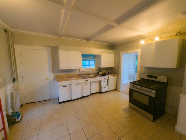kitchen featuring gas stove, white cabinets, light tile patterned floors, a sink, and coffered ceiling