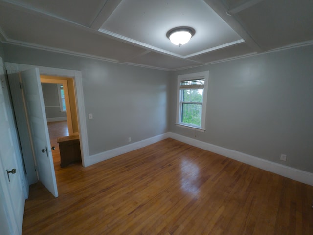 unfurnished room with wood finished floors, baseboards, and ornamental molding