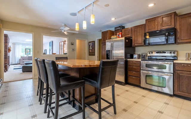 19 Brookside Dr, Falmouth, ME 04105 - kitchen featuring stainless steel appliances, light floors, a breakfast bar, a center island, and recessed lighting