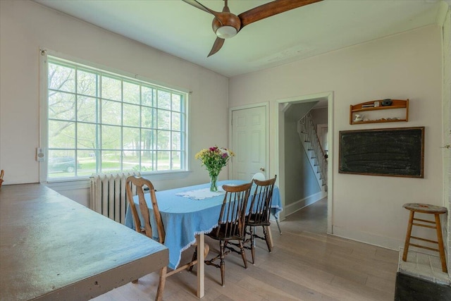 34 Admonten Ave, Rockland, ME 04841 - dining area with wood finished floors, ceiling fan, stairway, baseboards, and radiator heating unit