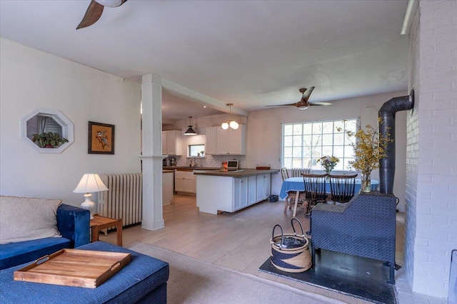 34 Admonten Ave, Rockland, ME 04841 - living area with ceiling fan, radiator, light wood-style floors, and a wood stove