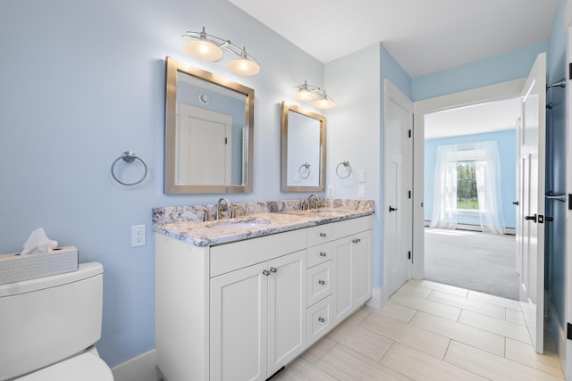 246 Coombs Rd, Brunswick, ME 04011 - bathroom featuring toilet, double vanity, baseboards, and baseboard heating