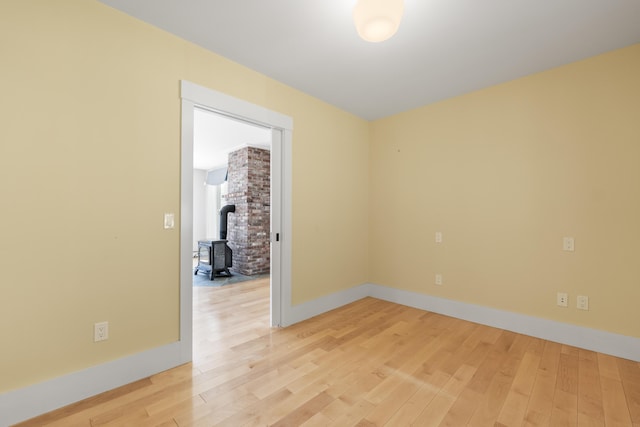 246 Coombs Rd, Brunswick, ME 04011 - spare room featuring light wood-style floors, a wood stove, and baseboards