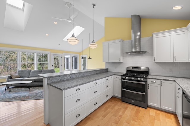 246 Coombs Rd, Brunswick, ME 04011 - kitchen with stainless steel appliances, a skylight, wall chimney exhaust hood, lofted ceiling, and light wood-type flooring