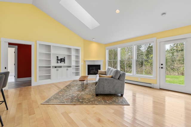 246 Coombs Rd, Brunswick, ME 04011 - living room with a baseboard heating unit, a skylight, plenty of natural light, high vaulted ceiling, and a glass covered fireplace