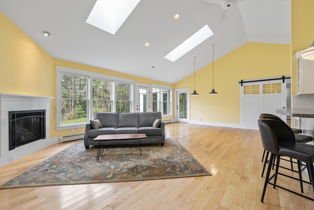 246 Coombs Rd, Brunswick, ME 04011 - living room with a skylight, high vaulted ceiling, a glass covered fireplace, light wood finished floors, and baseboard heating