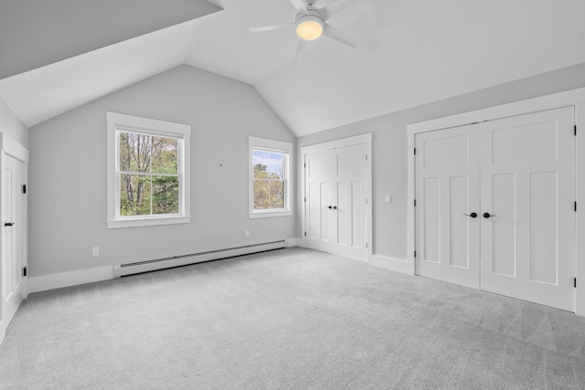 246 Coombs Rd, Brunswick, ME 04011 - unfurnished bedroom with a baseboard heating unit, multiple closets, carpet, vaulted ceiling, and baseboards