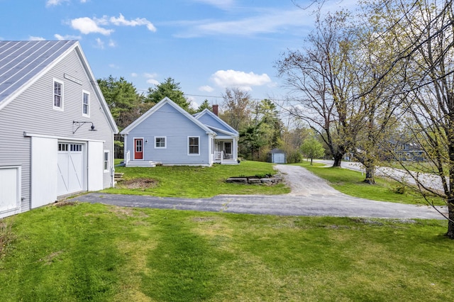 246 Coombs Rd, Brunswick, ME 04011 - view of side of property featuring a storage shed, an outbuilding, asphalt driveway, a yard, and a garage