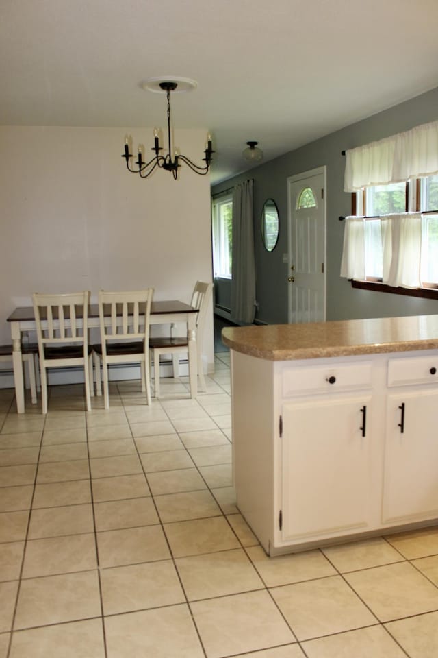 74 Fields Pond Rd, Holden, ME 04429 - kitchen featuring a chandelier, light tile patterned floors, white cabinets, pendant lighting, and a baseboard heating unit