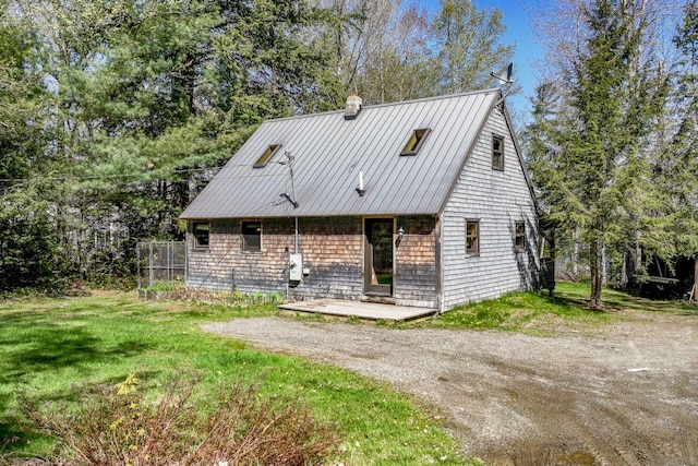 40 Birch Way, Stetson, ME 04488 - view of front facade with a chimney, a front lawn, a metal roof, and dirt driveway