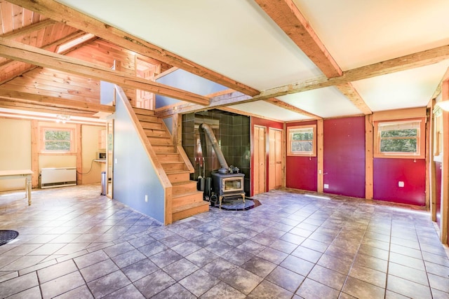 40 Birch Way, Stetson, ME 04488 - unfurnished living room featuring a wood stove, beam ceiling, and stairway