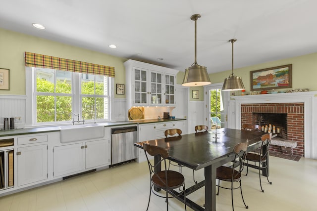 37 Mountain St, Camden, ME 04843 - kitchen featuring stainless steel dishwasher, a sink, white cabinetry, decorative light fixtures, and a fireplace