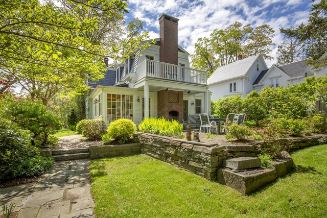 37 Mountain St, Camden, ME 04843 - rear view of property featuring a balcony, a chimney, a yard, a patio, and brick siding
