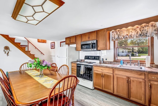 117 Pinkhams Cove Rd, Belgrade, ME 04917 - kitchen featuring white appliances, a sink, brown cabinets, tasteful backsplash, and light wood-style floors