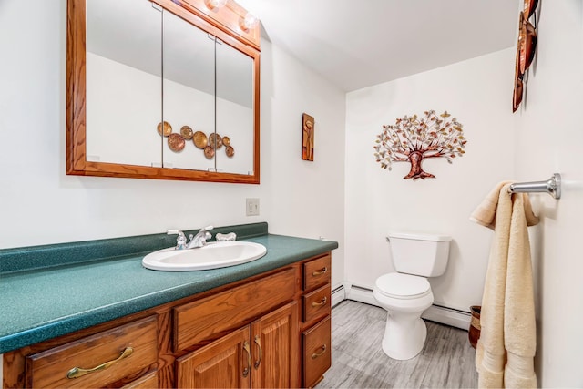 117 Pinkhams Cove Rd, Belgrade, ME 04917 - bathroom featuring a baseboard heating unit, vanity, toilet, and wood finished floors