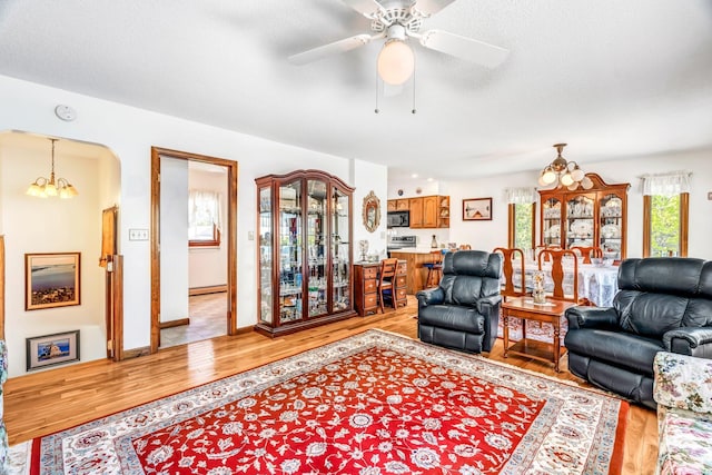 117 Pinkhams Cove Rd, Belgrade, ME 04917 - living area with light wood-style flooring, a chandelier, ceiling fan, and arched walkways
