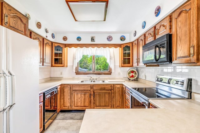 117 Pinkhams Cove Rd, Belgrade, ME 04917 - kitchen featuring stainless steel range with electric cooktop, black microwave, freestanding refrigerator, a sink, and brown cabinets