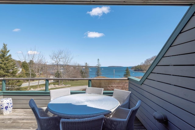 wooden terrace featuring a water view and outdoor dining space