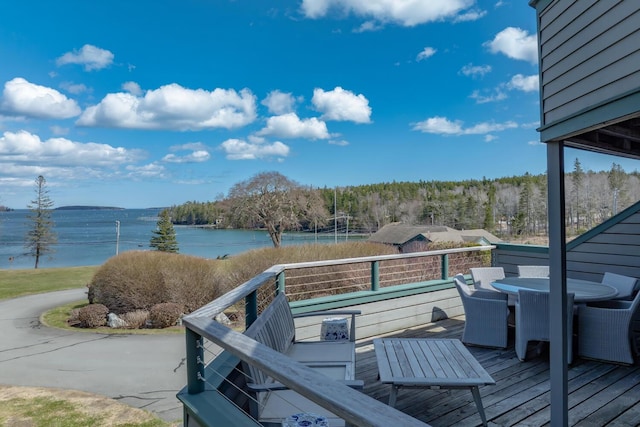 wooden terrace with outdoor dining area and a water view
