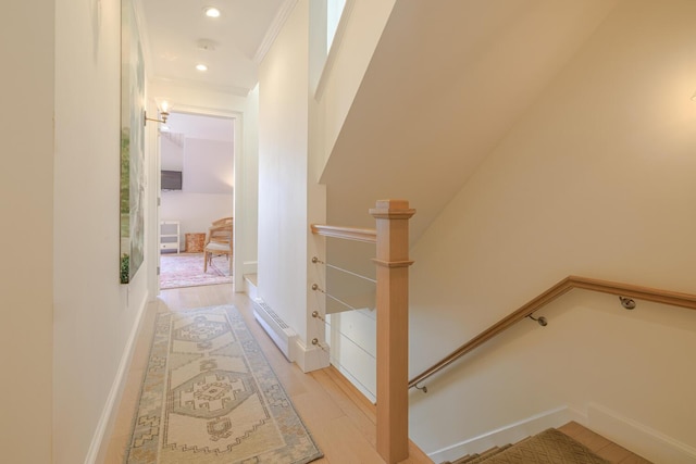 stairs with wood finished floors, recessed lighting, and crown molding