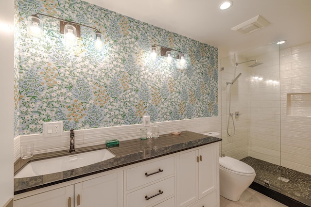 full bath featuring wallpapered walls, tiled shower, toilet, tile walls, and vanity