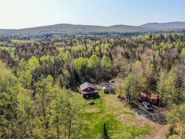aerial view of property and surrounding area with a forest and a mountainous background