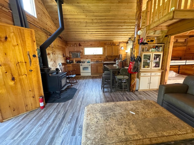 living room with a wood stove, high vaulted ceiling, dark wood finished floors, wooden walls, and wood ceiling