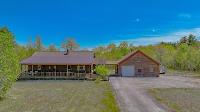 19 Pine Acres Dr, Cornish, ME 04020 - view of front of home with a garage, driveway, a chimney, metal roof, and a front yard
