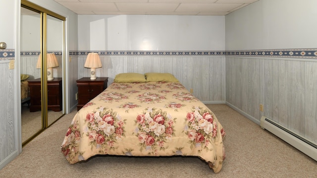 19 Pine Acres Dr, Cornish, ME 04020 - bedroom featuring baseboard heating, carpet floors, a wainscoted wall, a closet, and wood walls