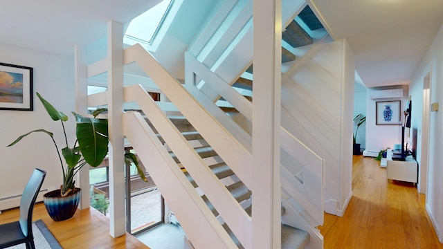 28 Meadow Ln, Brewer, ME 04412 - staircase with an AC wall unit, wood finished floors, a skylight, and a baseboard radiator